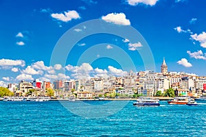 Beyoglu historic district and Galata tower medieval landmark with sightseeing ships. Istanbul, Turkey