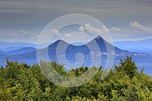 Bezdez Hill, in Kokorinsko mountain, Czech Republic. Hill with clouds. Beautiful morning landscape. Village below the hill. Landsc