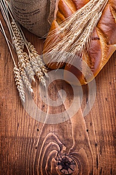 Bguettes and wheat ears on vintage wooden board