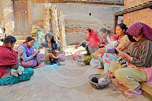 BHAKTAPUR, NEPAL - DECEMBER 29, 2014: Young women knitting outside their home