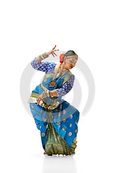 Bharatanatyam dance. Beautiful, talented indian woman in traditional clothes dancing against white studio background