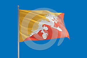 Bhutan national flag waving in the wind on a deep blue sky. High quality fabric. International relations concept
