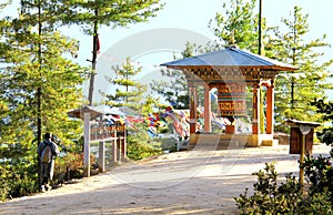 Bhutanese man in traditional cloth walking near the prayer wheel