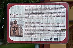 Biale, Poland - August 04, 2017: Information plate in front of the Church p.w. St. Joseph in Biale, Gostynin. Poland. Was elevated