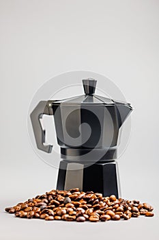 Bialetti moka pot. Coffee maker and coffee beans on gray background