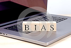 BIAS word on wooden block on laptop , business concept
