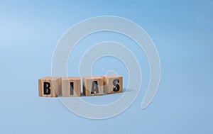 Bias - word from wooden blocks with letters, personal opinions prejudice bias concept, blue background