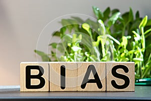 Bias - word from wooden blocks with letters, personal opinions prejudice bias concept, random letters around