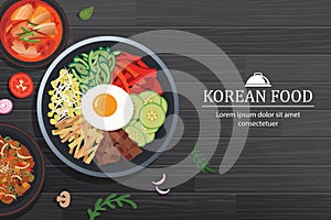 Bibimbap in the bowl on black wood table top view. Korea food background