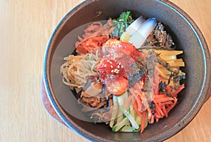 Bibimbap, a Flavorful Korean Traditional Mixed Rice with Meat and Assorted Vegetables in Hot Stone Bowl