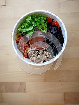 Bibimbap, traditional Korean dish in a take away box, rice with vegetables and beef.