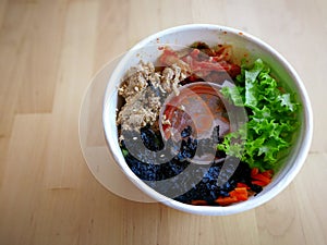 Bibimbap, traditional Korean dish in a take away box, rice with vegetables and beef.