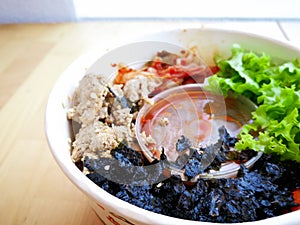 Bibimbap, traditional Korean dish in a take away box, rice with vegetables and beef.