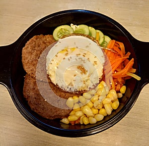 Bibimbap is a typical korean food cintai ing rice, egg, meat and vegetables