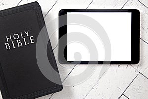 Bible and Blank Tablet on a White Wooden Surface