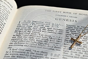 Bible Book of Genesis Chapter 1 with a gold cross