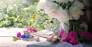 Bible and a bouquet of peonies on a table in the garden