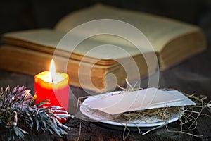 Bible and christmas red candle on the table by night