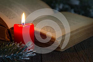 Bible and christmas red candle on the table by night