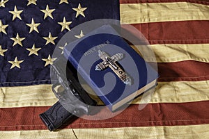 Bible cross and gun on American flag