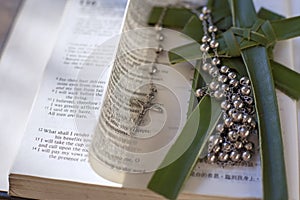 Bible with cross and rosary beads