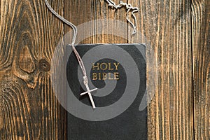 Bible and cross on a wood background. Study Bible worship concept.