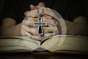 Bible and hands holding a rosary