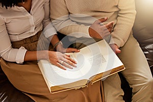 Bible, hands and reading with a black couple together in their home for religion, faith or belief in God. Jesus, pray or