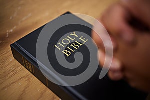 Bible, hands and woman in prayer in home, lounge and reading book of faith, religion and worship study for mindfulness