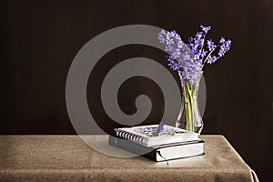Bible and journal placed on a table with flowers in vase