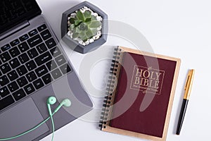 Bible and laptop on the work table with headphones. Bible Study Online