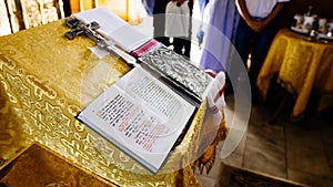 Bible on reading-desk, sacred lectern in the church decorated with golden friezes and ornaments, open book - gospel in Old Russian