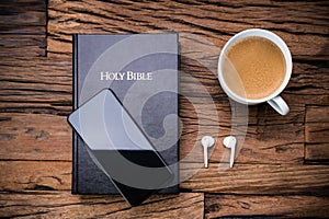 Bible And A Smart Phone With Earphones And Teacup