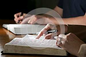 Un uomo e una donna studiare la Bibbia insieme(Immagine Cristiana, poco profondo punto di messa a fuoco sul primo piano womans puntatore a forma di mano)