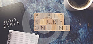 Bible Study Online Written in Block Letters on a Blue Wood Table with a Bible