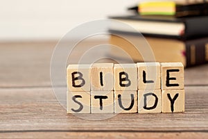 Bible study text on wood cubes on rustic table with Holy Bible, notebook, and pen in the background