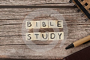 Bible study text word written on wooden cubes with holy bible, pen, and notebook on wooden table