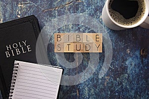 Bible Study Written in Block Letters on a Blue Wood Table with a Bible
