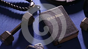Bible Surrounded by Various Gym Equipment