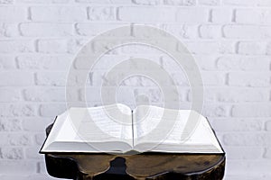 Bible on the table. On the background of a brick wall. Open Holy Bible