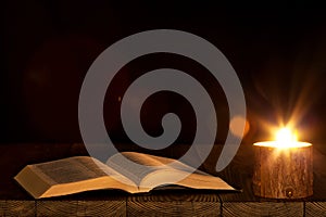 A bible on the table in the light of a candle