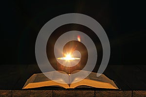 A bible on the table in the light of a candle