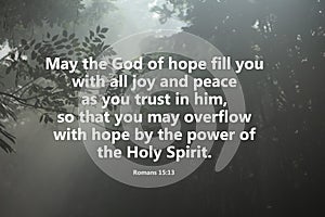 Bible verse about hope, joy and peace. Believe in God. On natural rays background of foggy through the forest..