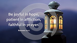 Bible verse quote - Be joyful in hope, patient in affliction, faithful in prayer. Romans 12:12. With lantern light at night.