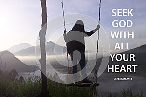 Bible verse quote - Seek God with all your heart. Jeremiah 29:13 With woman standing on wooden swing looking at misty morning view photo