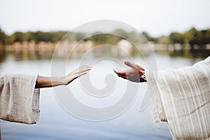 Biblical scene - of a female grabbing the hand of Jesus Chris with a blurred background