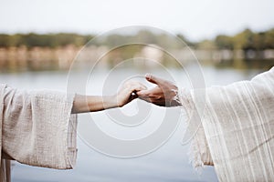 Biblical scene - of a female grabbing the hand of Jesus Christ with a blurred background photo