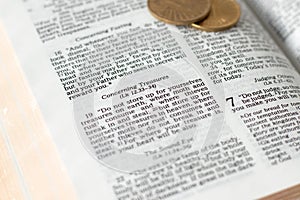 Biblical verses concerning treasures in open holy bible with golden coins
