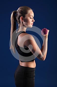 Bicep curl by beautiful young fitness woman