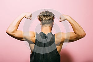 Biceps concept. Athlete show biceps and triceps, back view. Man flex arms with biceps. Biceps muscle of arms